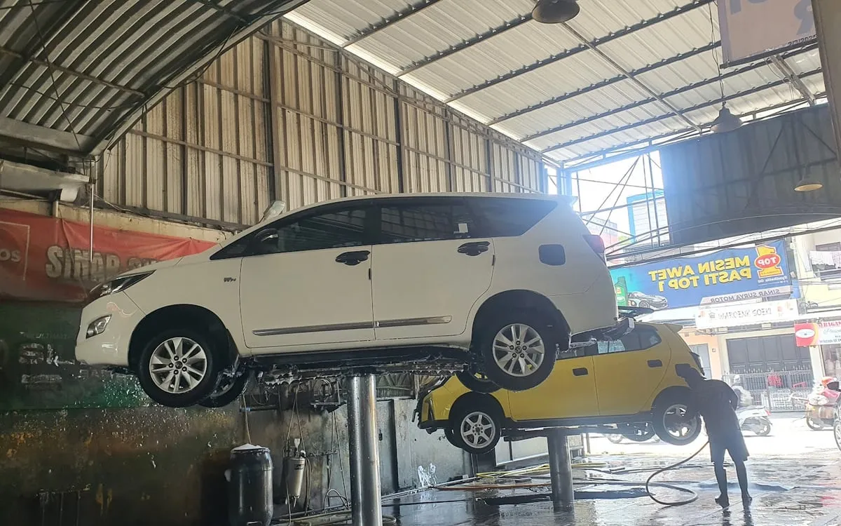 Mobil diangkat lift hidrolik untuk cuci kolong di Sinar Surya Auto Care Bojongsoang, Bandung